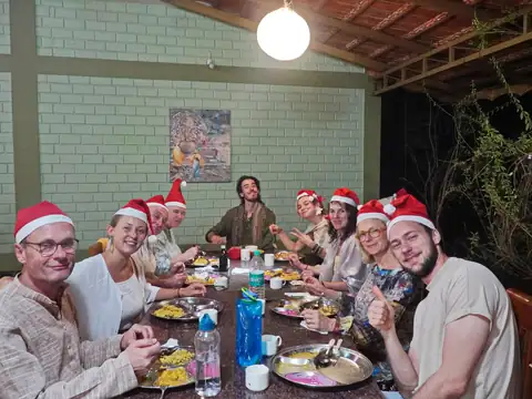 Christmas yoga retreat in India – guests in Santa hats at Christmas dinner at AyurYoga Eco-Ashram